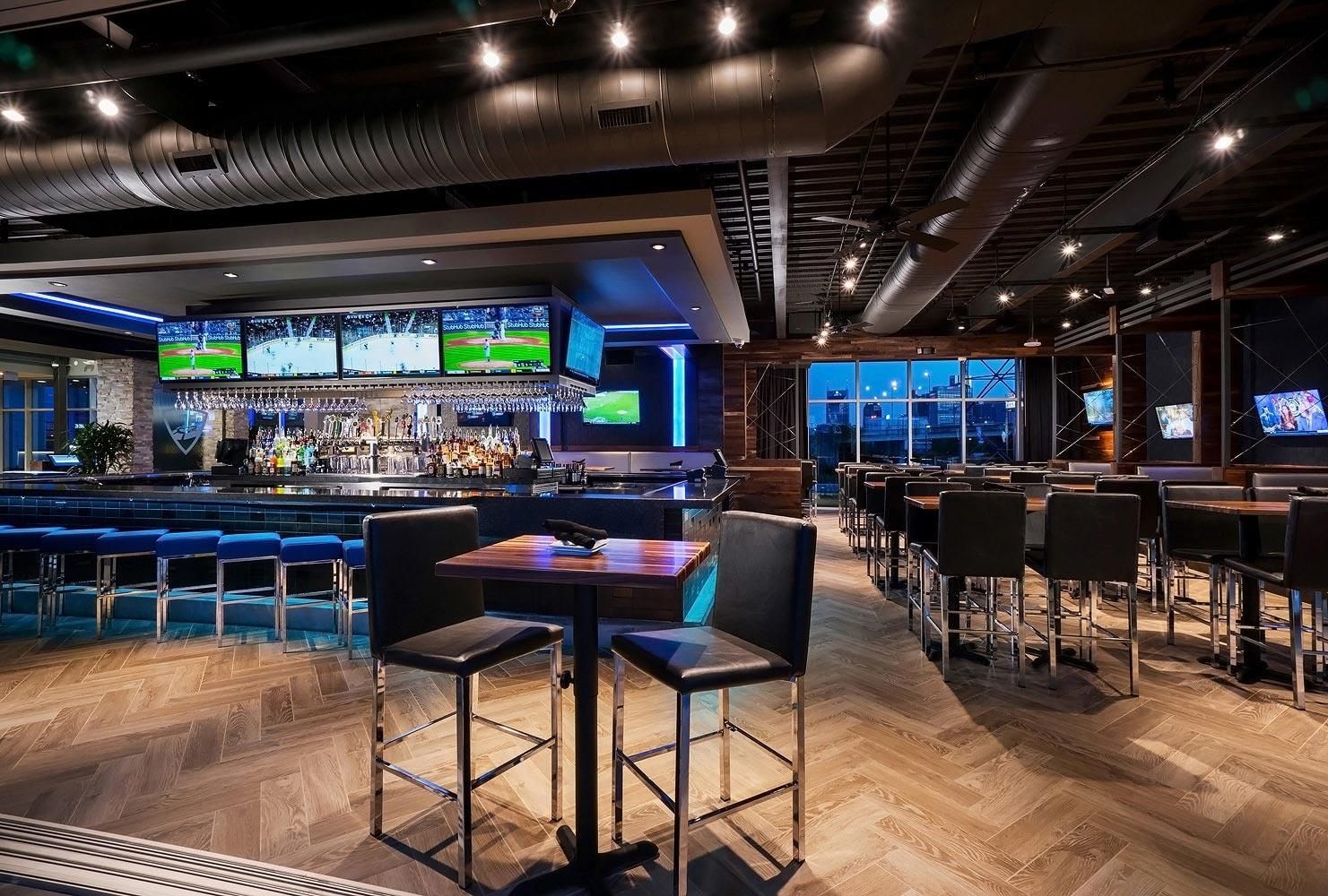 Sports bar with high black chairs an distributed video screens.